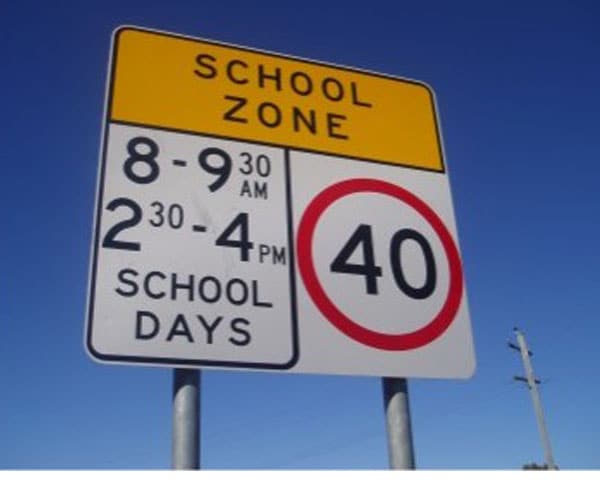 School zone sign displaying speed limit of 40 km/h with designated hours for reduced speed on school days.