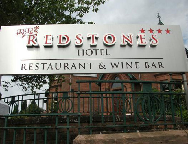 Redstones Hotel sign featuring the name in bold letters, indicating a restaurant and wine bar, with decorative elements and three stars above.