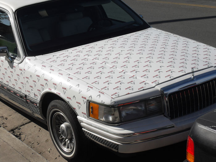 Limo wrapped in 3M Vehicle Vinyl with a step and repeat pattern, showcasing innovative advertising by 858 Graphics.