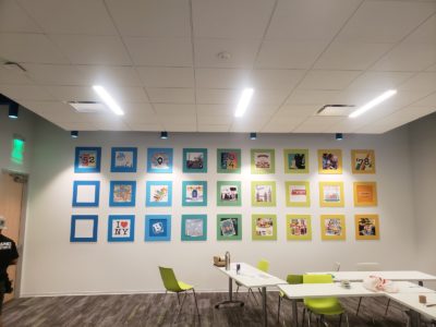 Colorful wall graphics displayed in square frames, enhancing an office space with vibrant designs and modern aesthetics, complementing the themes of branding and workspace transformation.