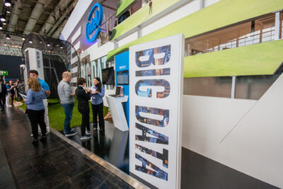 Big Data display at a trade show booth with attendees engaging, showcasing 858 Graphics' custom pop-up display solutions for events.