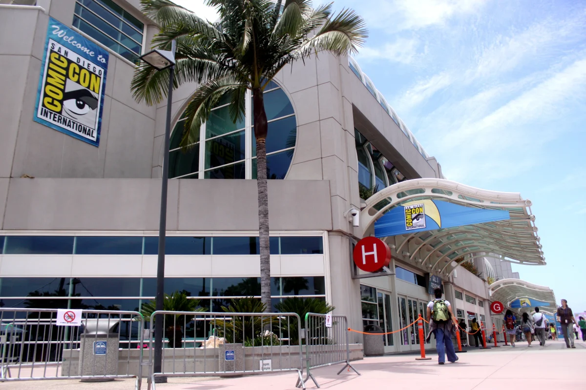 San Diego Comic-Con International logo banners on convention center exterior with palm trees.