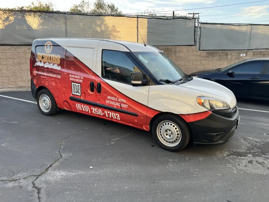 Professional washing a wrapped vehicle to demonstrate maintenance of commercial wraps
