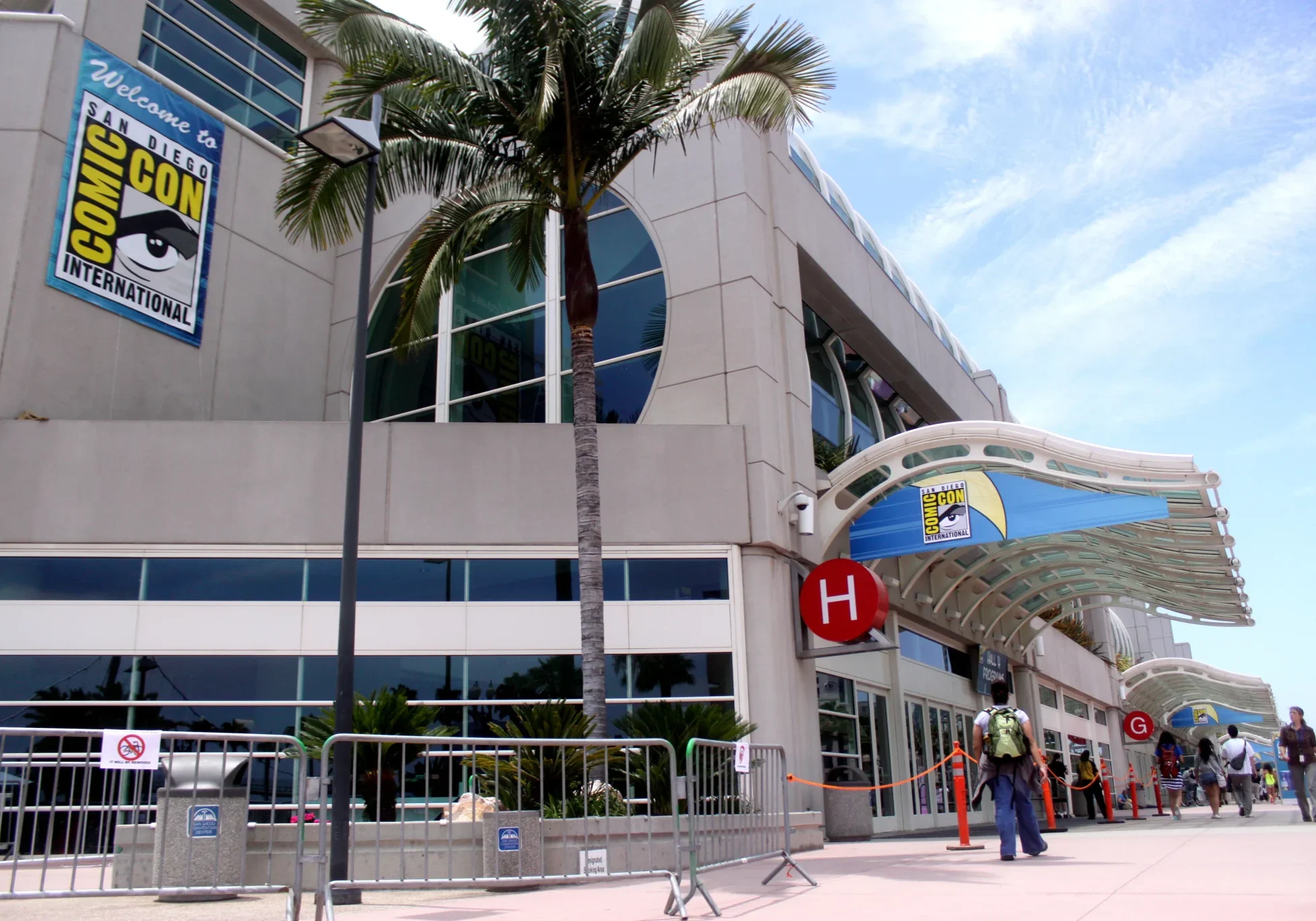 San Diego Comic-Con International logo banners on convention center exterior with palm trees.