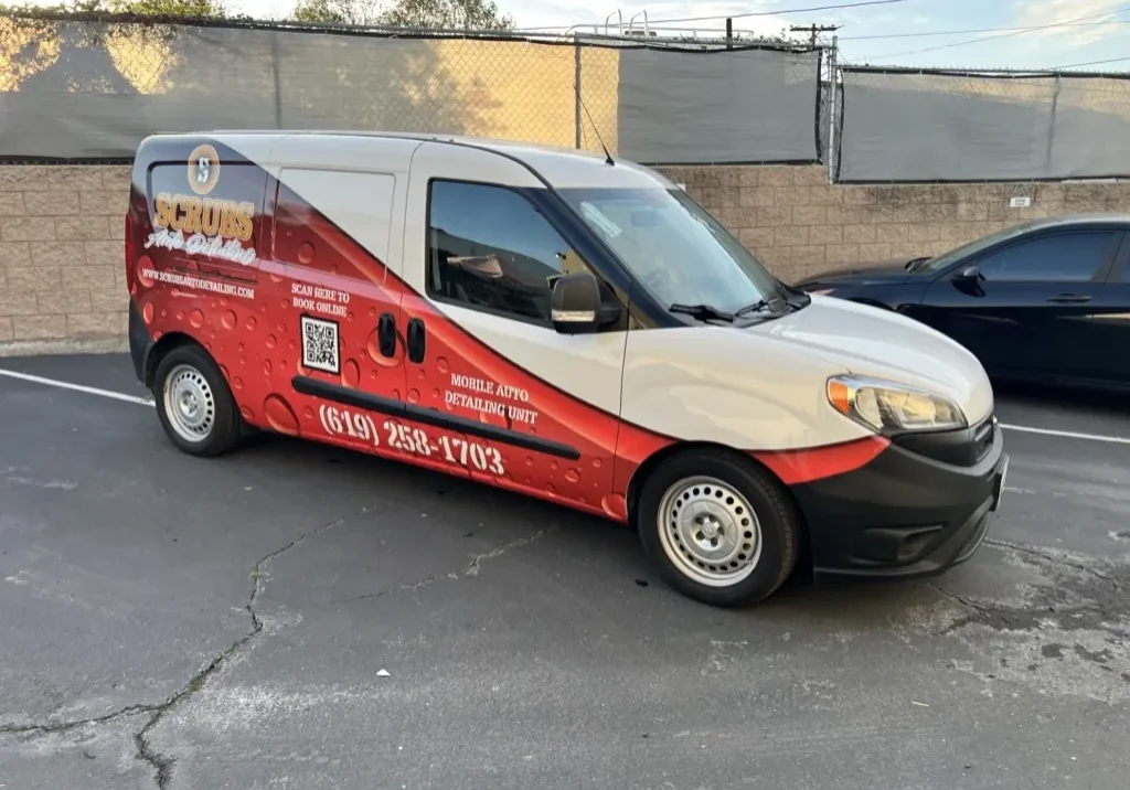 Professional washing a wrapped vehicle to demonstrate maintenance of commercial wraps
